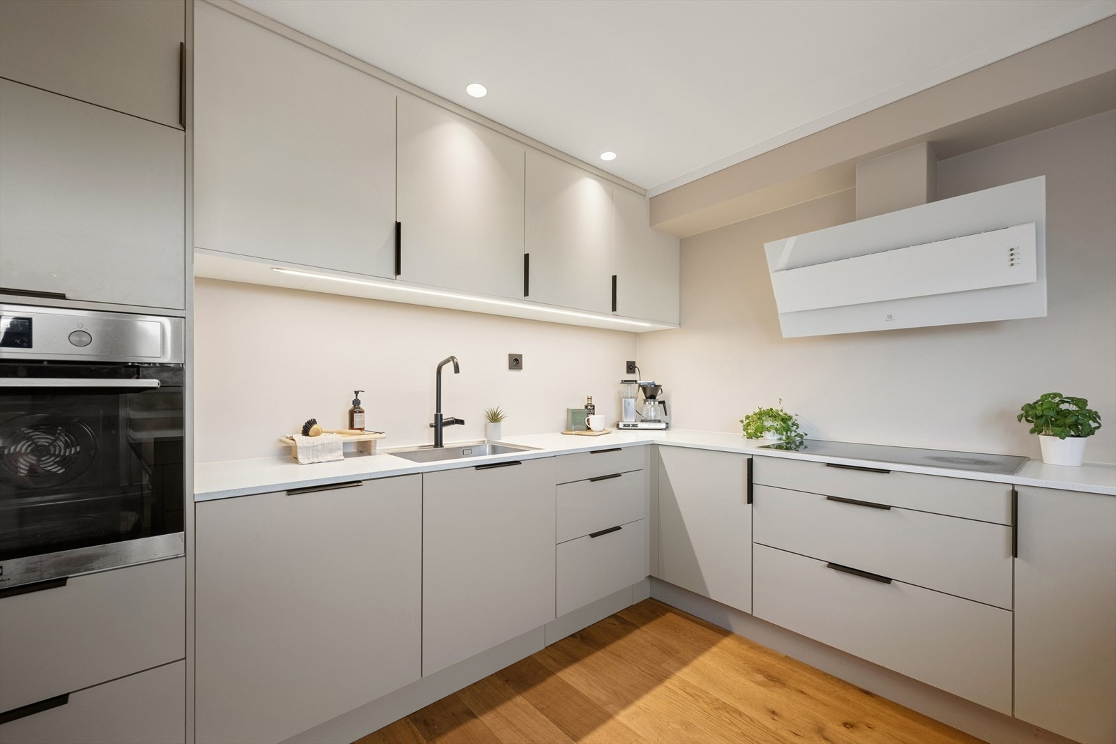 Integrerte hvitevarer og kjøkkenventilator med avtrekk ut gir et funksjonelt arbeidsområde. Galleribilde