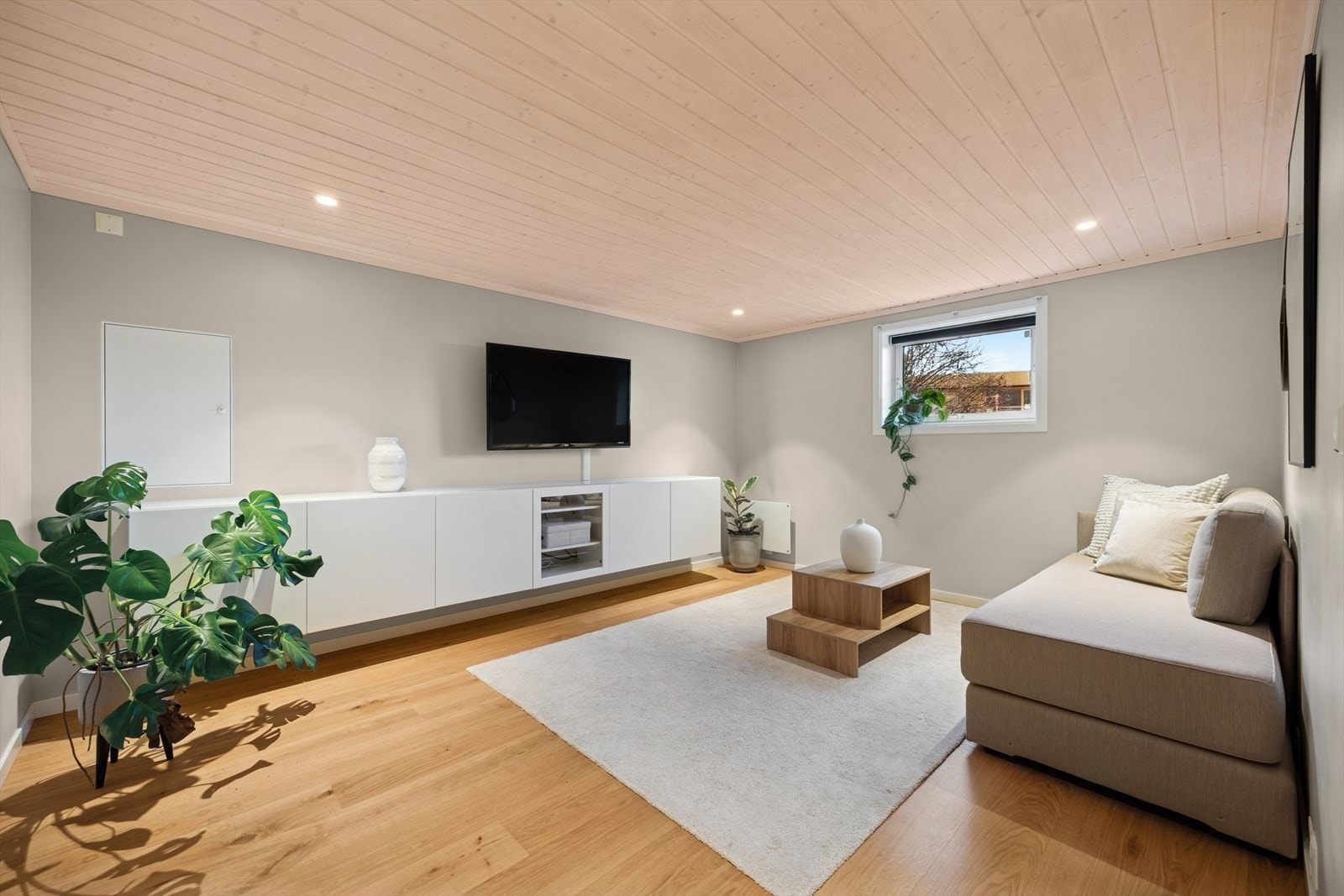 Parkettgulv og malte på veggene gir et stilrent uttrykk i rommet som har plass til å innrede med sofagruppe, vegghengt TV og oppbevaringsenhet. Galleribilde