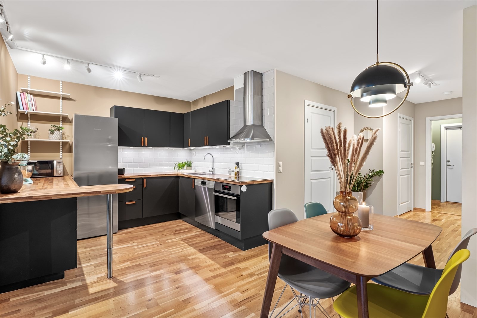 Kjøkkeninnredning med malte, sorte fronter og benkeplate i laminat. En del av kjøkkeninnredningen og benkeplaten er fra 2015. Galleribilde