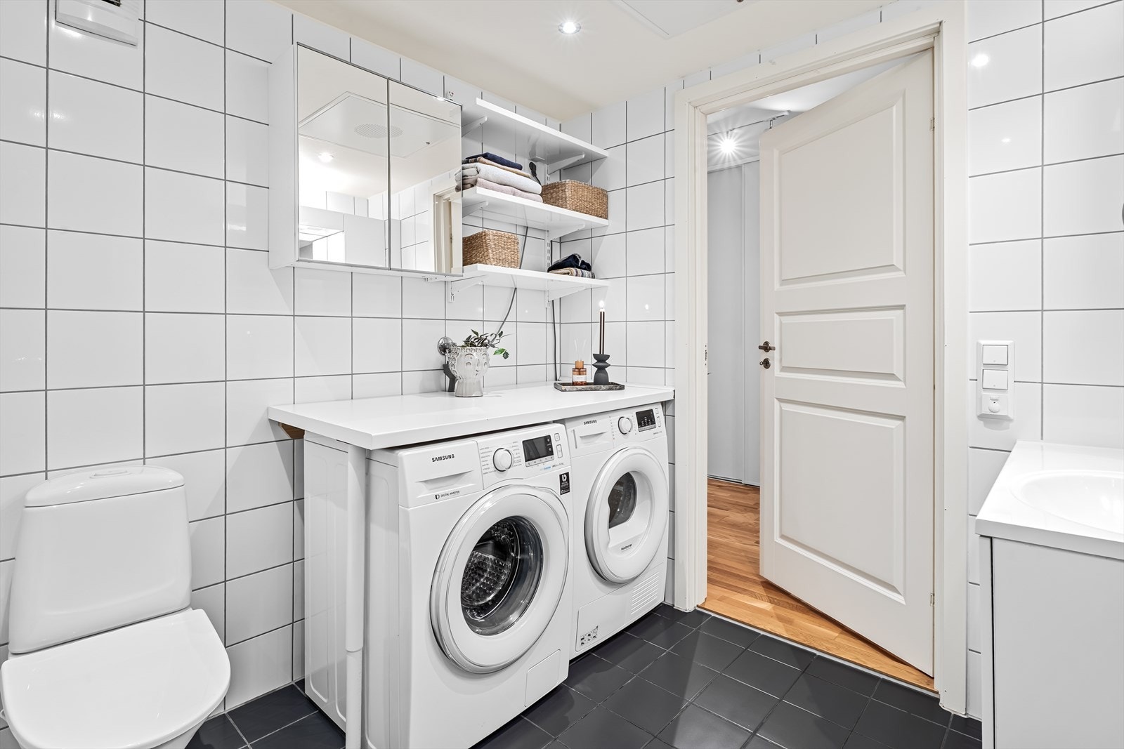 Innredningen består av baderomsinnredning med glatte, folierte fronter og heldekkende servant. Praktisk benk- og hylleløsning over vaskemaskin/tørketrommel som kan benyttes som stellebord m.m. Galleribilde