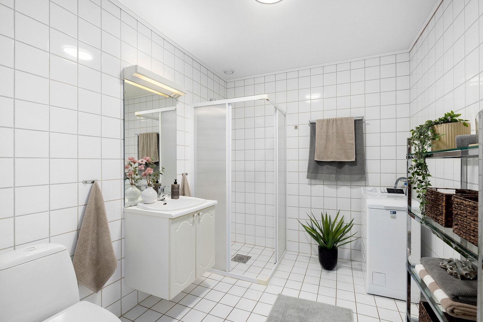 Lyst og delikat baderom med opplegg for vaskerom. Galleribilde