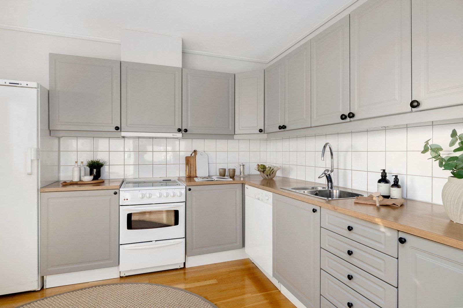 Kjøkkenet har frittstående hvitevarer og er malt i en lys, delikat farge. Galleribilde