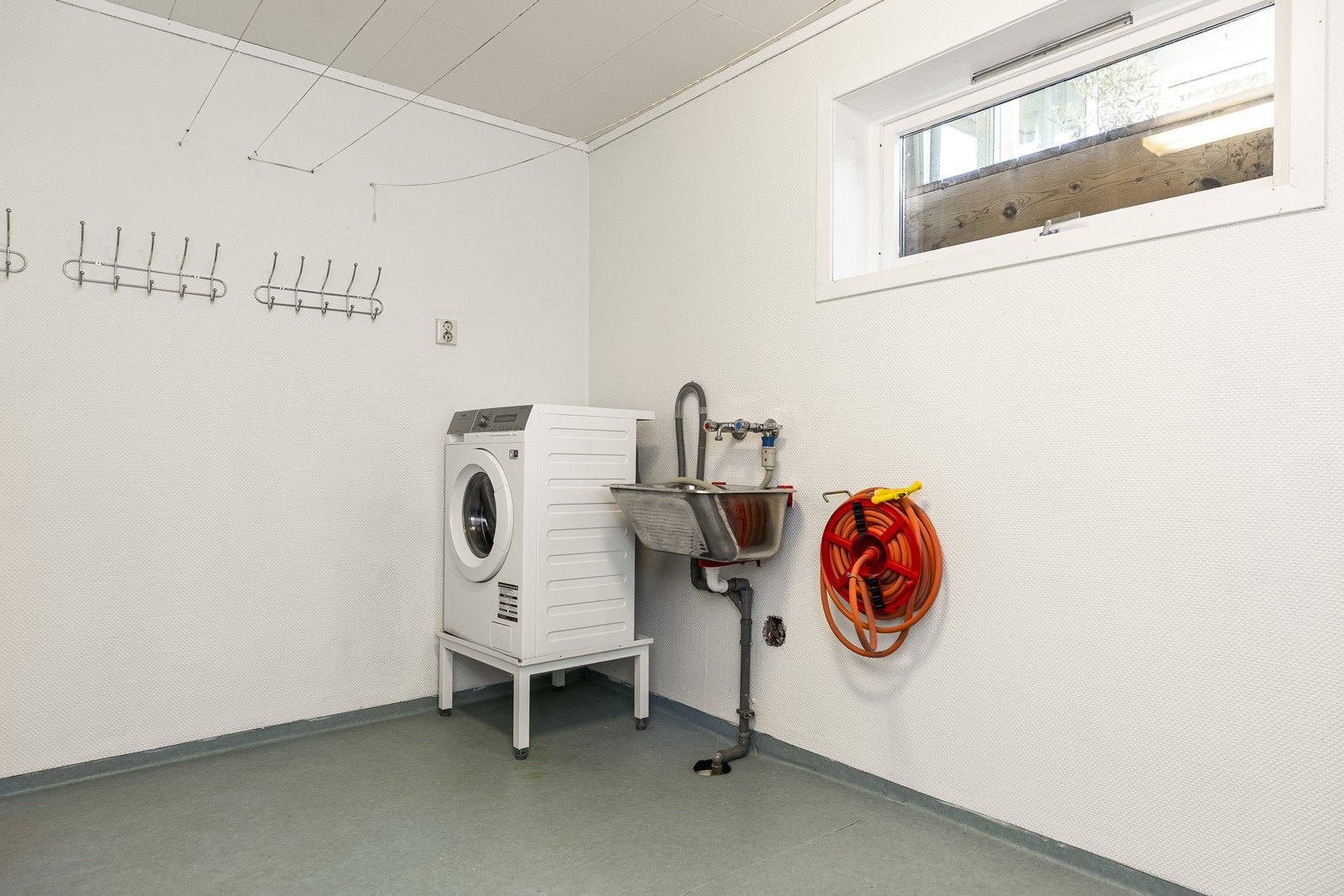 Separat vaskerom i kjelleren med opplegg for vaskemaskin og utslagsvask. Galleribilde