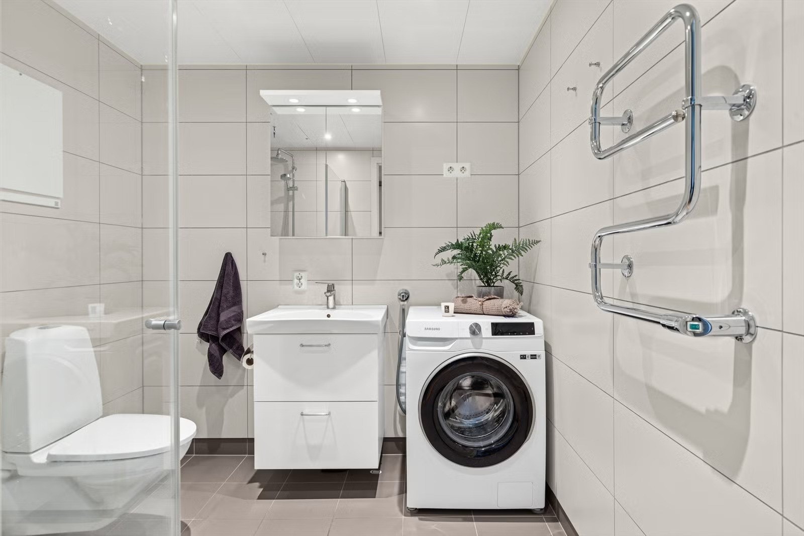 Lekkert flislagt bad med opplegg for vaskemaskin Galleribilde