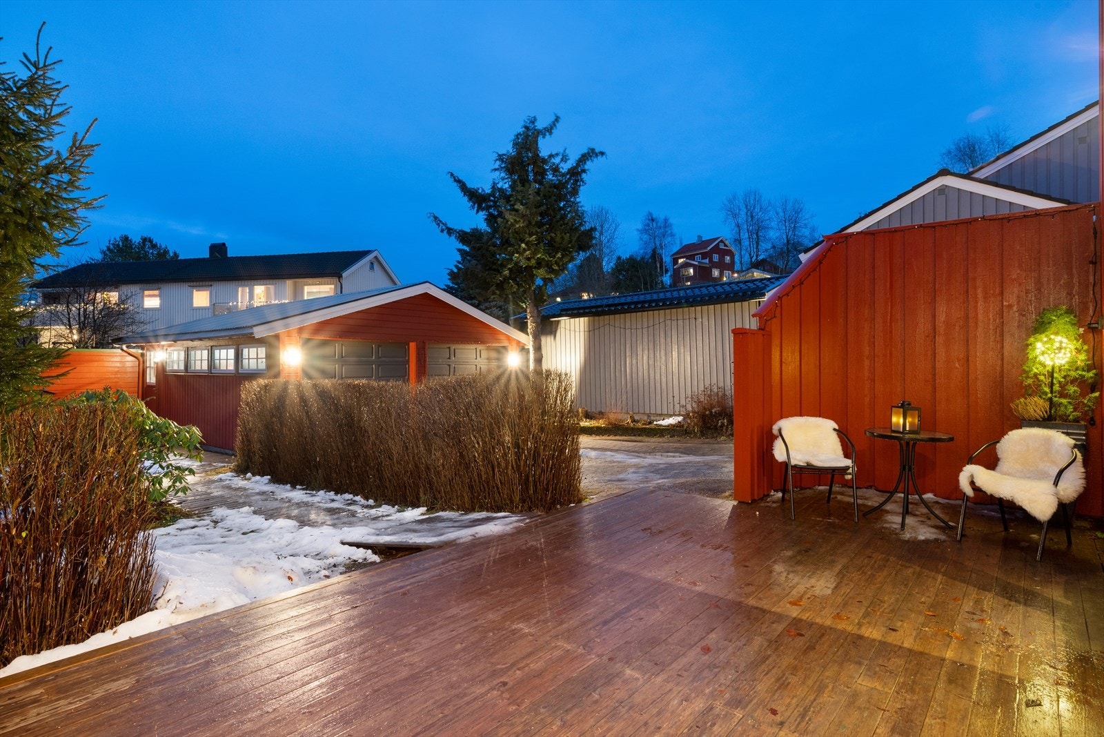 Tomten er pent opparbeidet med steinbelagt gårdsplass og en frodig hage Galleribilde