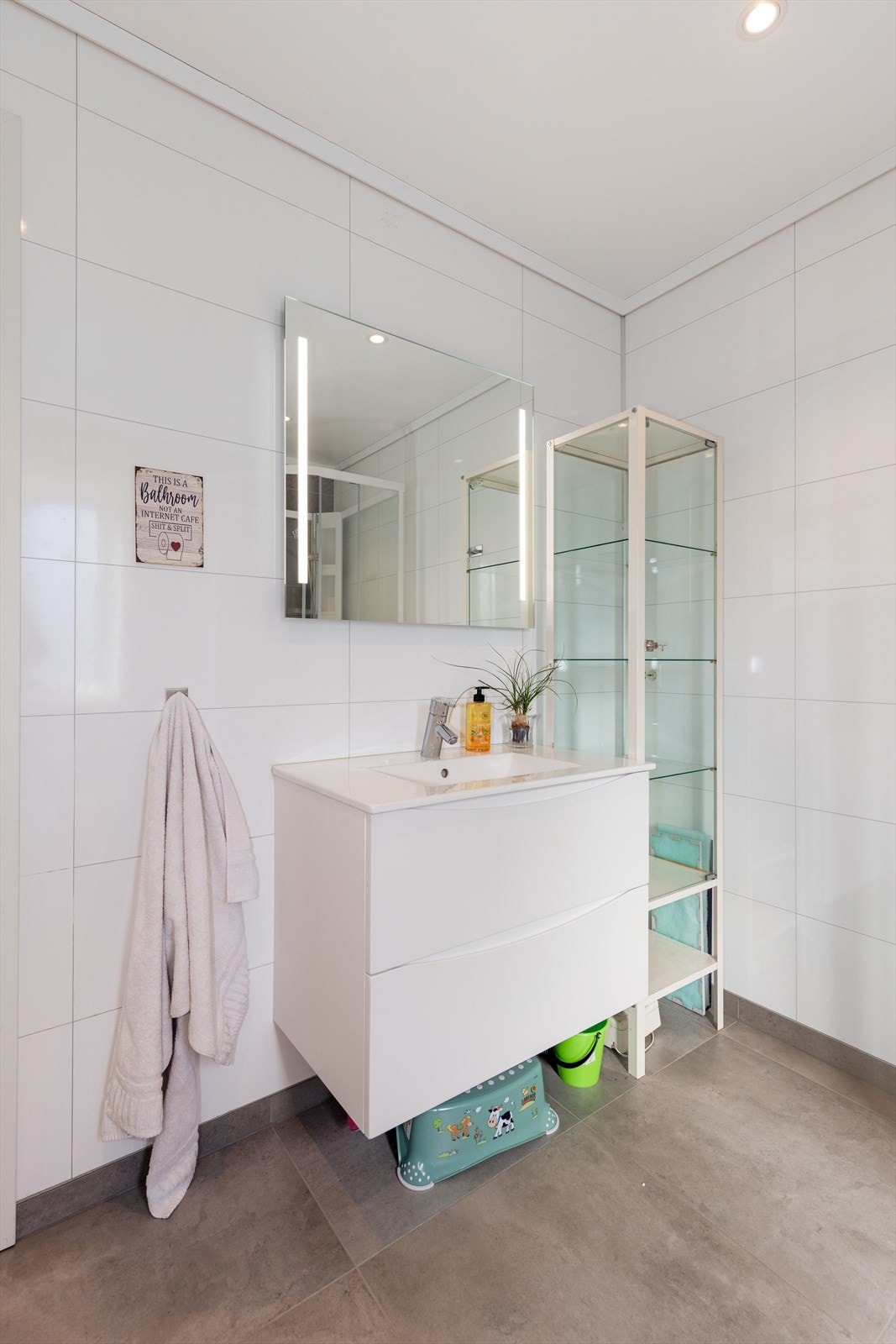 Badet har flis på gulv med varmekabler, baderomsplater på vegg og malte gipsplater i tak med innfelte spotter. Galleribilde