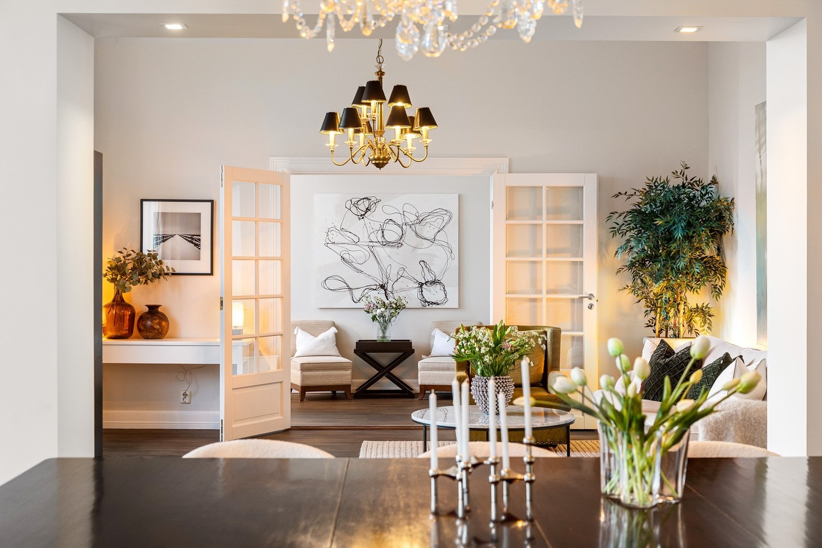 Leiligheten har tre stuer på rad. De klassiske detaljene som rosett og stukkatur tilfører rommet særpreg og eleganse, mens den imponerende takhøyden på 3,39 meter gir en luftig og åpen atmosfære. I hjørne av stuen vis a vi grønn plante er det pipeløp. Galleribilde