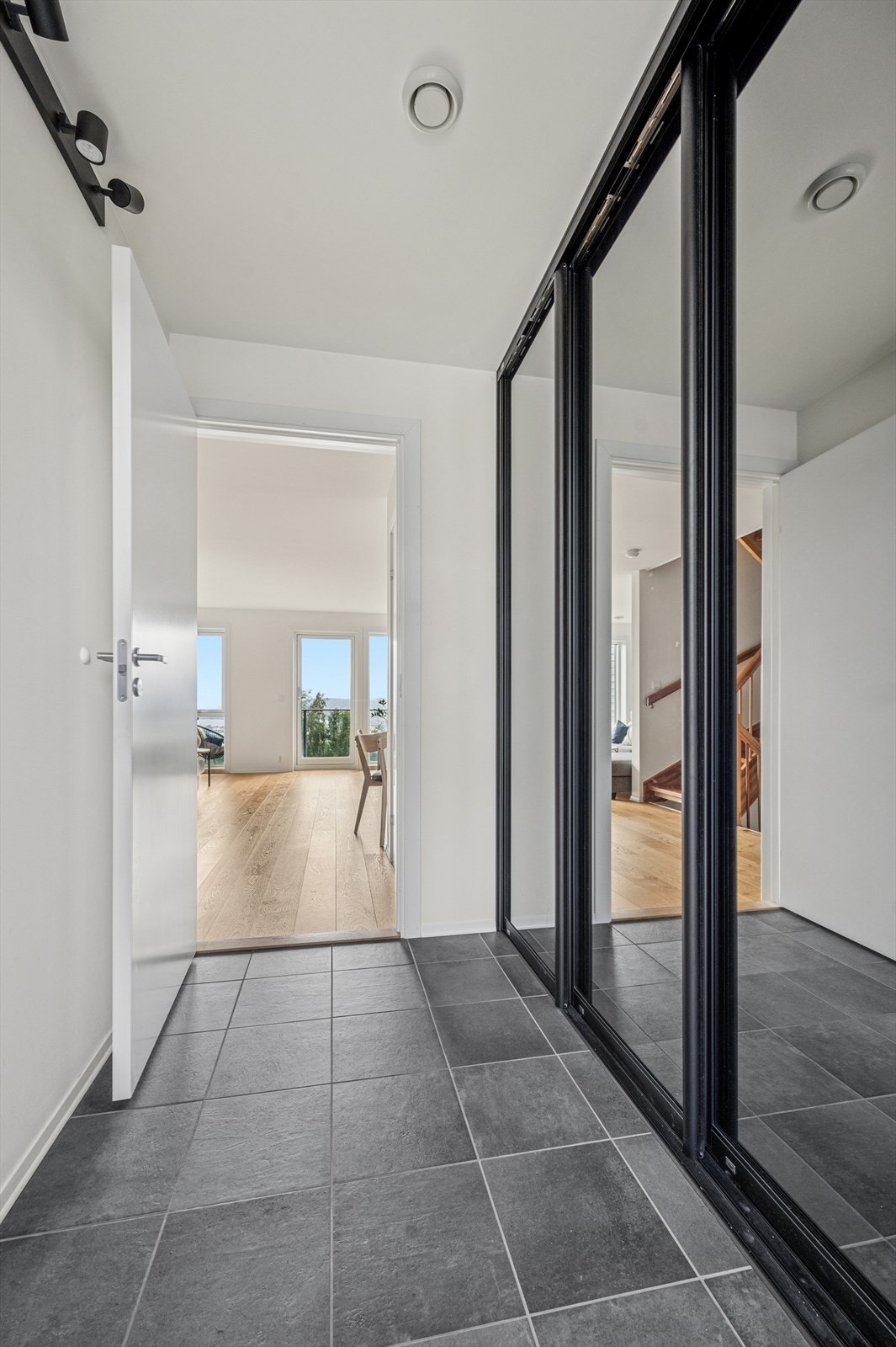 Entré med flislagt gulv med varme og skyvedørsgarderobe Galleribilde