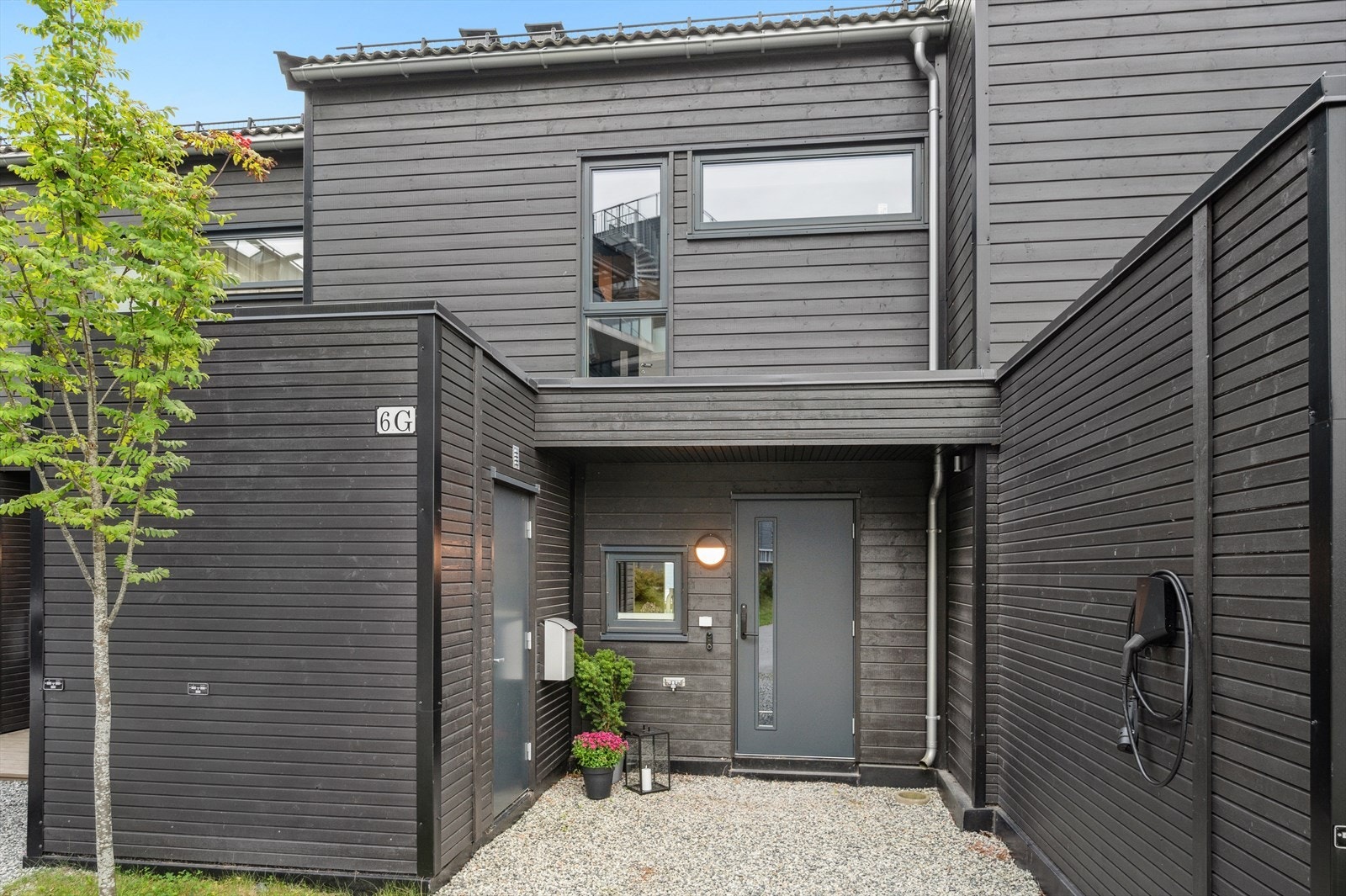 Inngansparti med sportsbod og elbillader Galleribilde