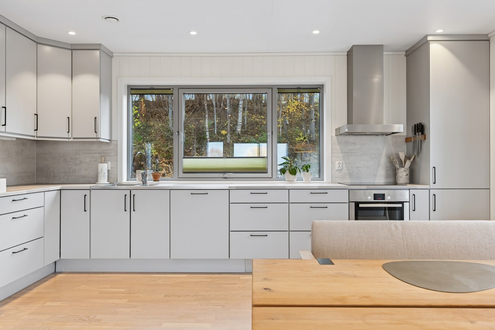 Stilren kjøkkeninnredning med folierte skrog, slette fronter og laminert benkeplate. Galleribilde