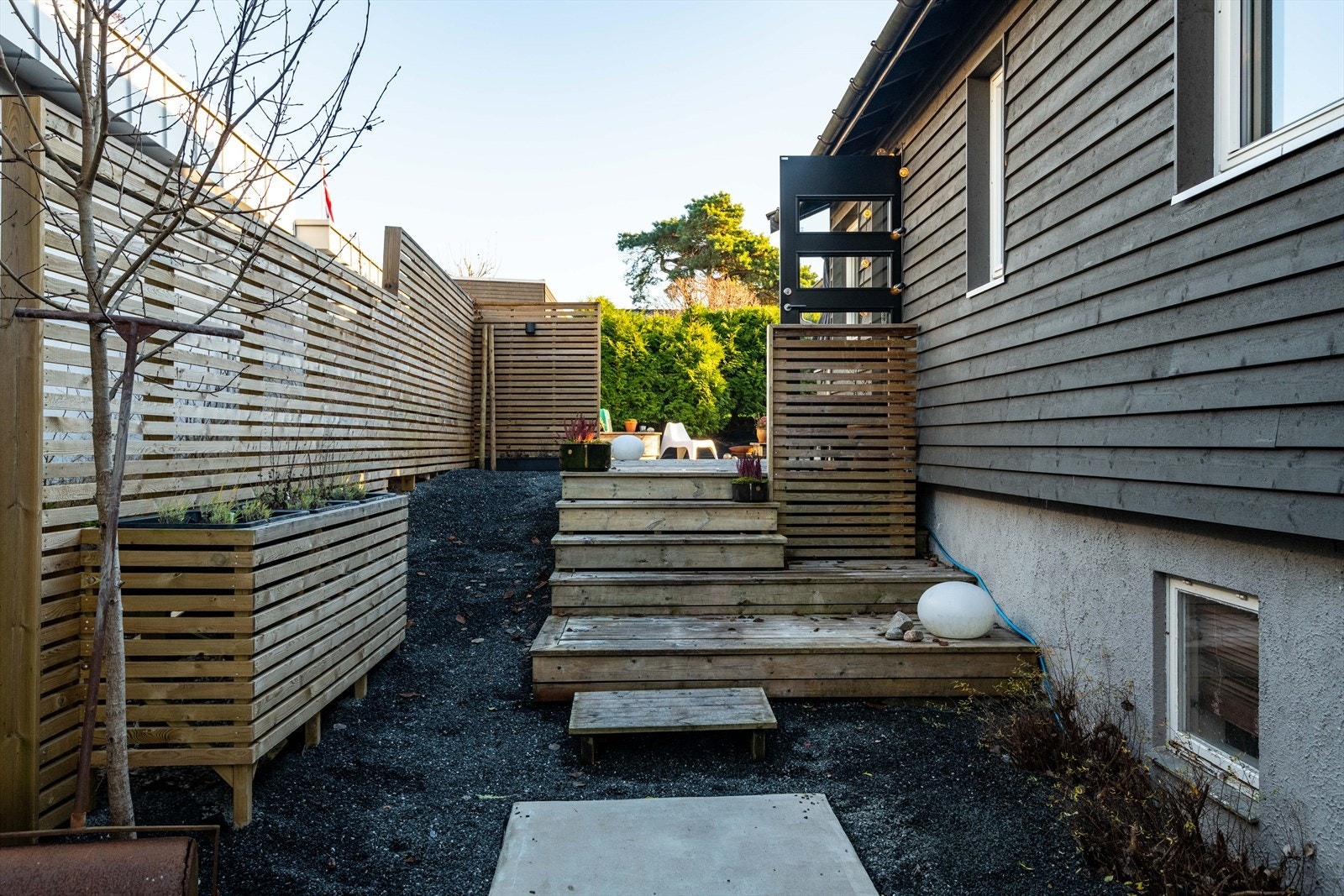 Pent opparbeidede uteområder med heller, trapper, blomsterkasser og grus Galleribilde