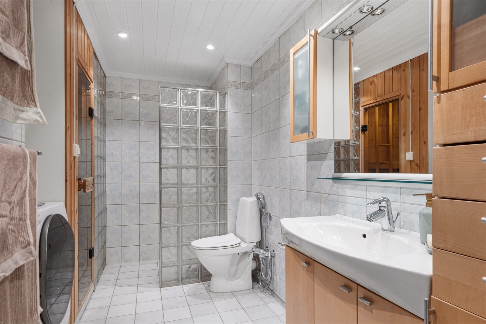 Flislagt baderom fra 2002, med egen dusjsone, toalett, innredning til oppbevaring og opplegg til vaskemaskin. Galleribilde