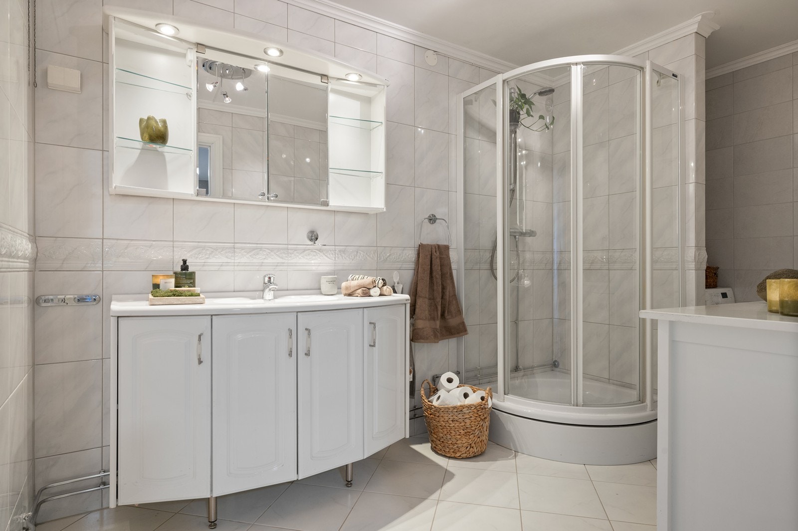 Badet er flislagt og utstyrt med dusjkabinett, servantinnredning og varme i gulvet. Galleribilde