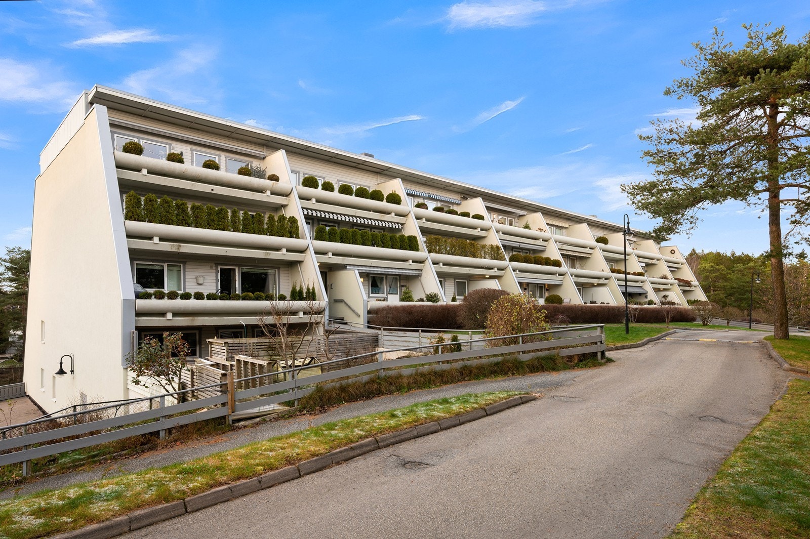 Bygningen har fasader med en kombinasjon av overflatebehandlet trepanel og pusset betong. Galleribilde