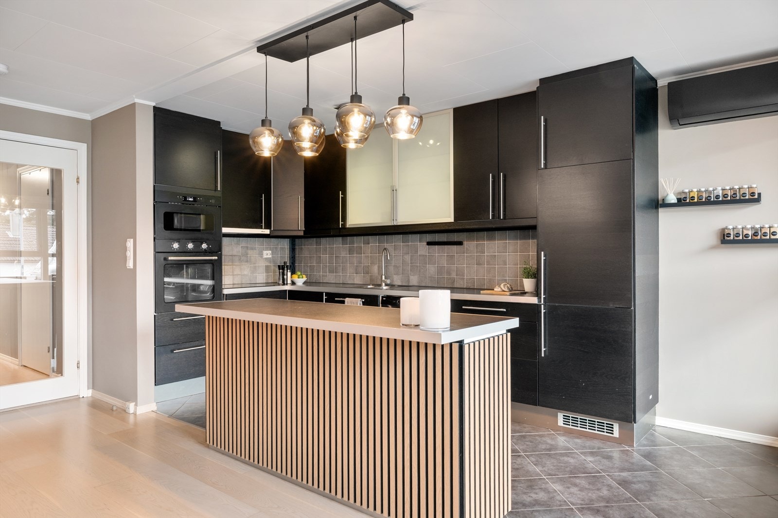 Planløsningen bidrar til en sosial atmosfære hvor man enkelt kan holde samtalen i gang med familie eller gjester mens man lager mat. Galleribilde