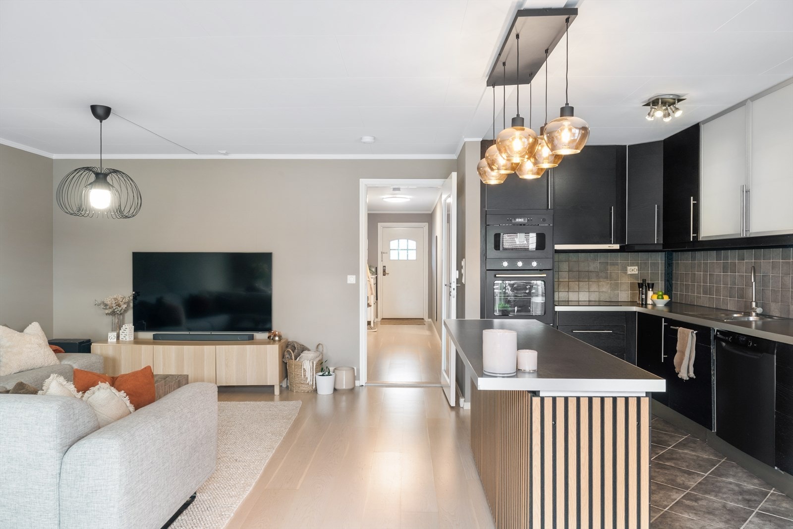 Kjøkkenet ligger i åpen forbindelse med stuen og fremstår som praktisk og funksjonelt med godt med skap- og benkeplass. Galleribilde