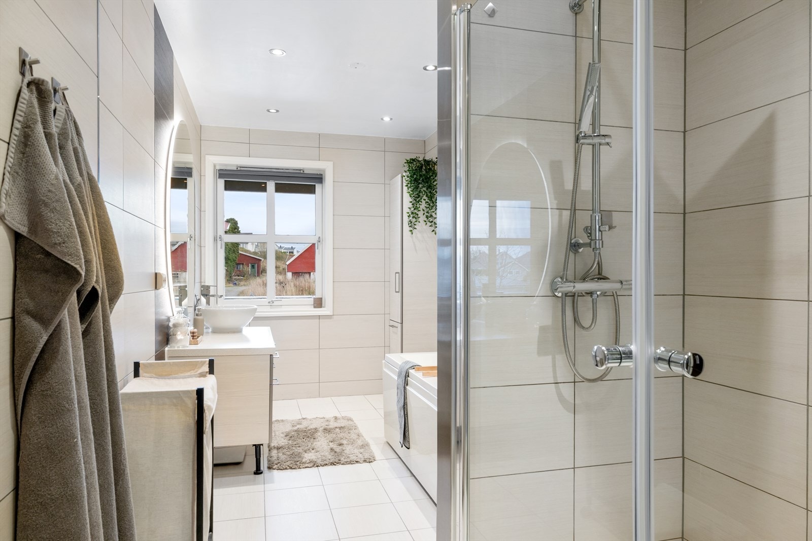 Badet i 1.etasje er utstyrt med elektriske varmekabler og innredet med servant, dusjhjørne og badekar. Galleribilde