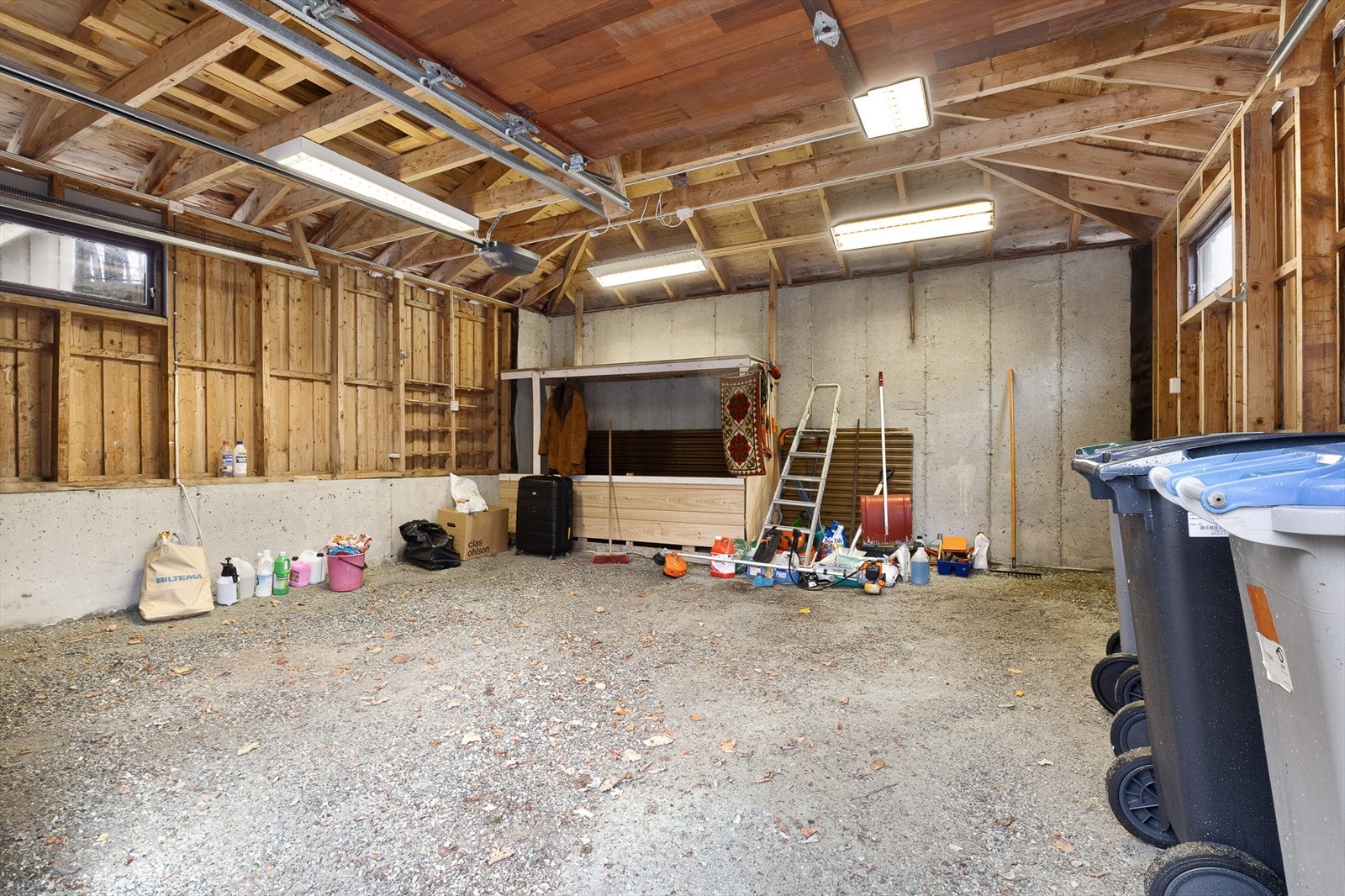 Garasjen er stor og har plass til to biler og hageredskaper. Galleribilde