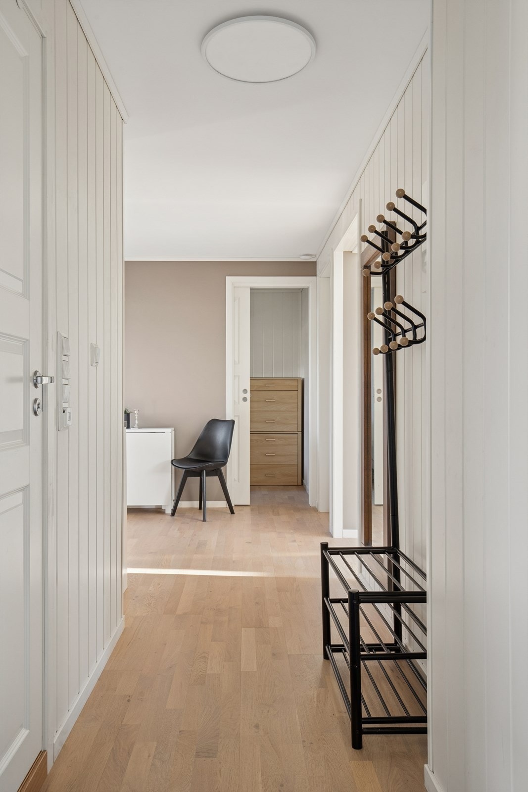 Lys og innbydende entré med plass til oppbevaring av yttertøy og sko. Rommet gir et ryddig førsteinntrykk og har praktisk adkomst til samtlige av boligens øvrige rom. Galleribilde