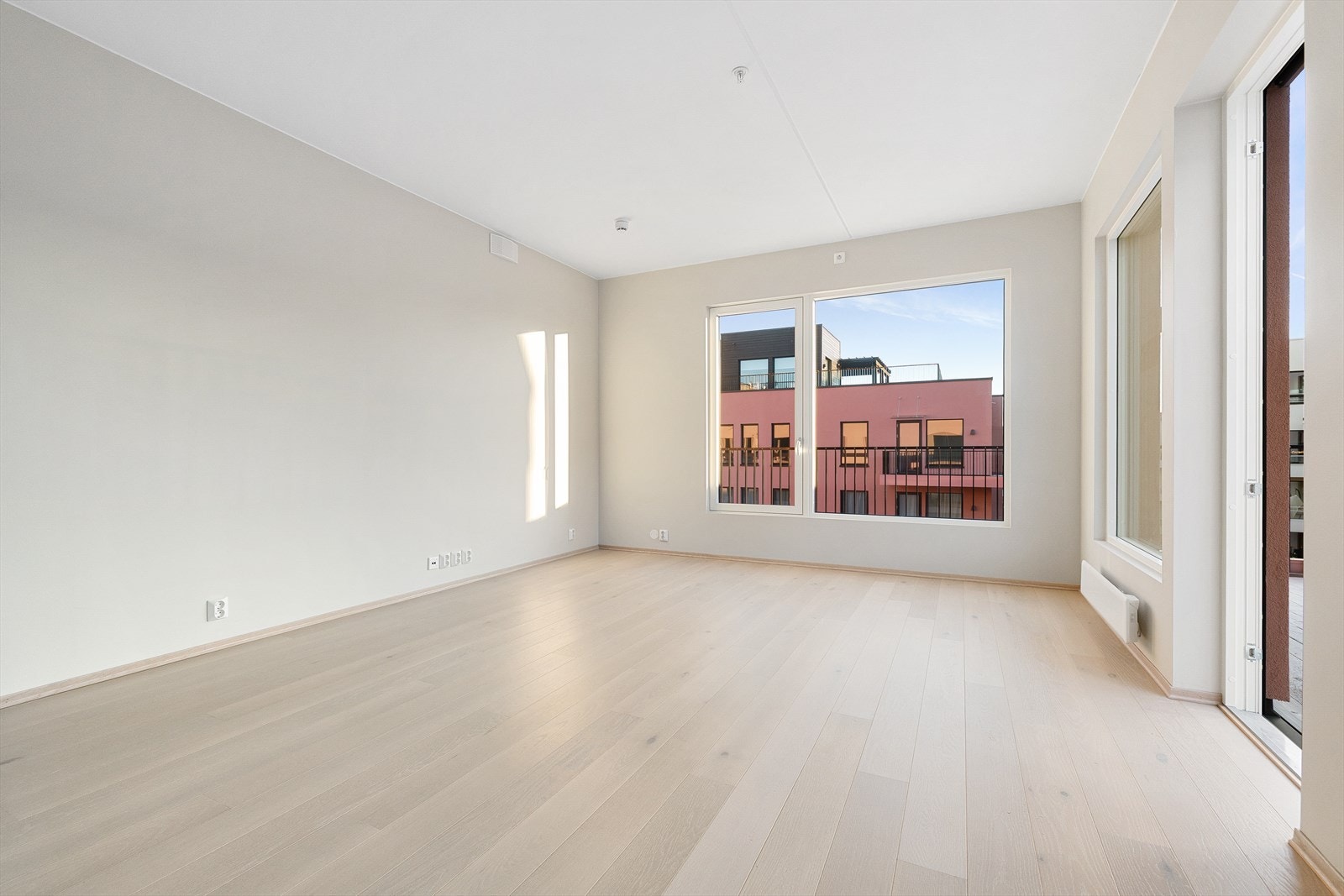 Stor og lys stue med vinduer på to sider. Galleribilde