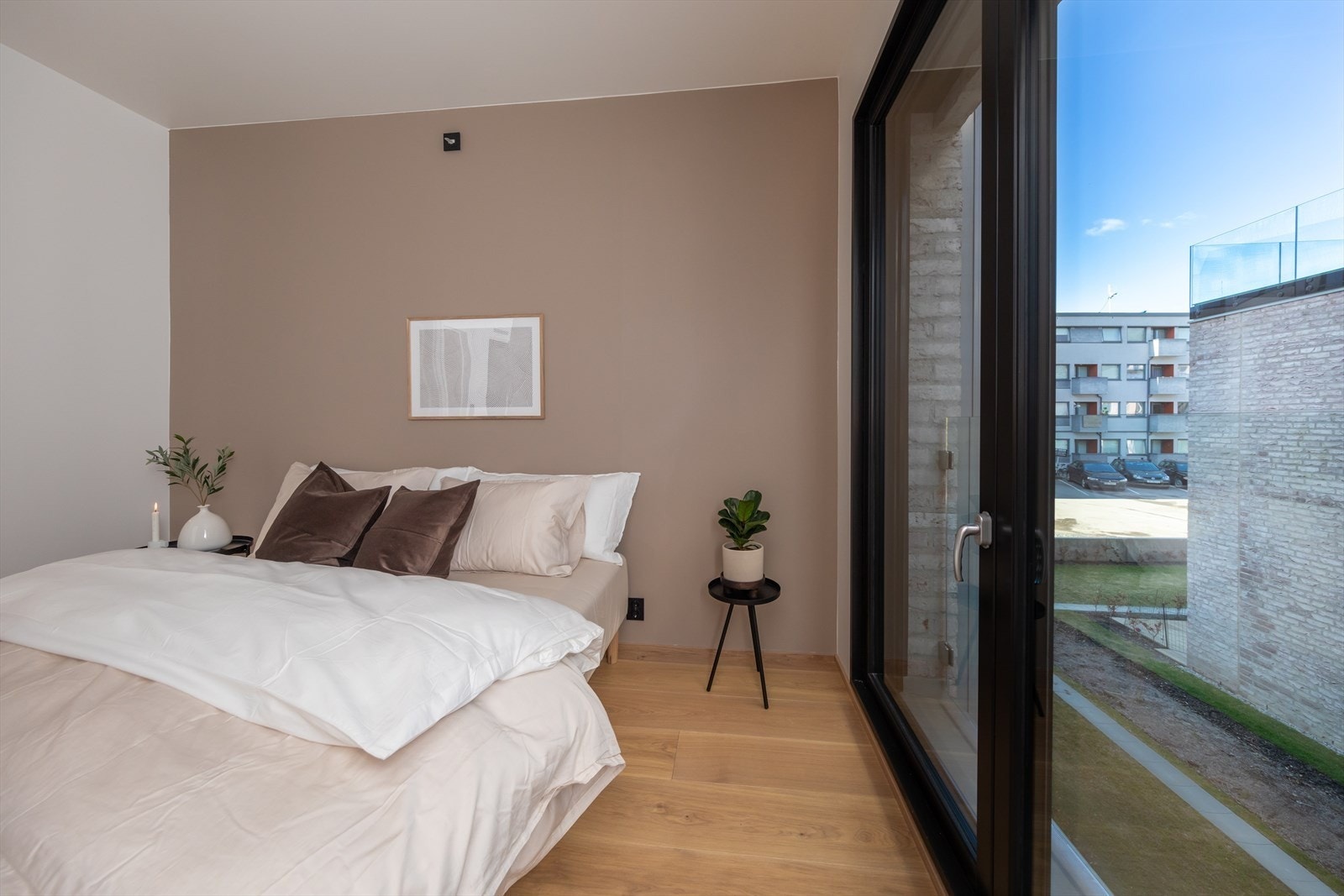 Lyst og romslig soverom med store vindusflater Galleribilde