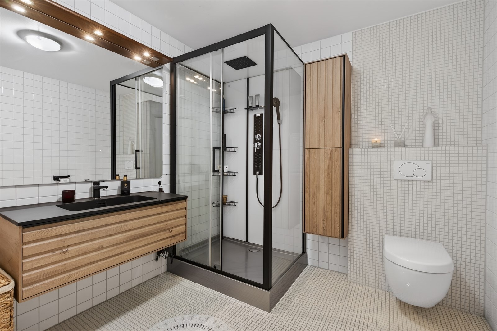 Helfliset baderom med moderne innredning med heldekkende servant, romslig dusjkabinett og vegghengt toalett. Varmekabler i gulv. Galleribilde