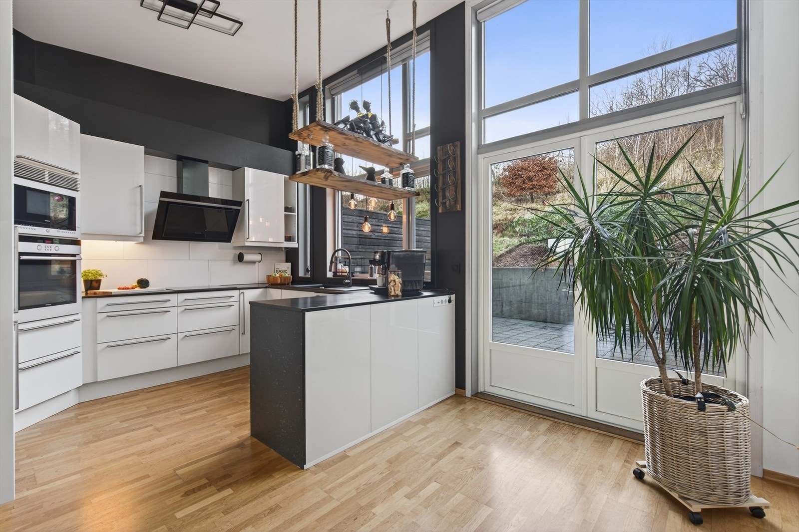 Pent kjøkken med slette fronter og integrerte hvitevarer. Galleribilde