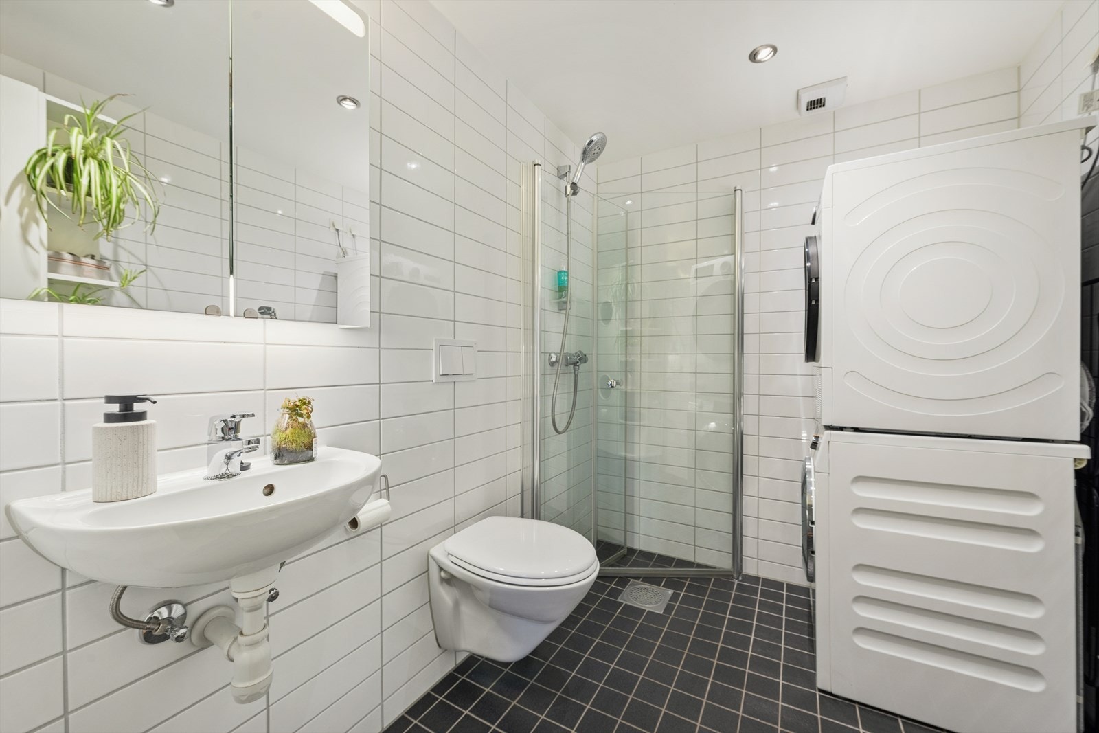 Boligen har to pene baderom. Her finner du lekre dusjløsninger med innfellbare glassdører i herdet glass, praktisk servant med underskap, vegghengt toalett og elegant speil. Her er det opplegg for vaskemaskin. Galleribilde