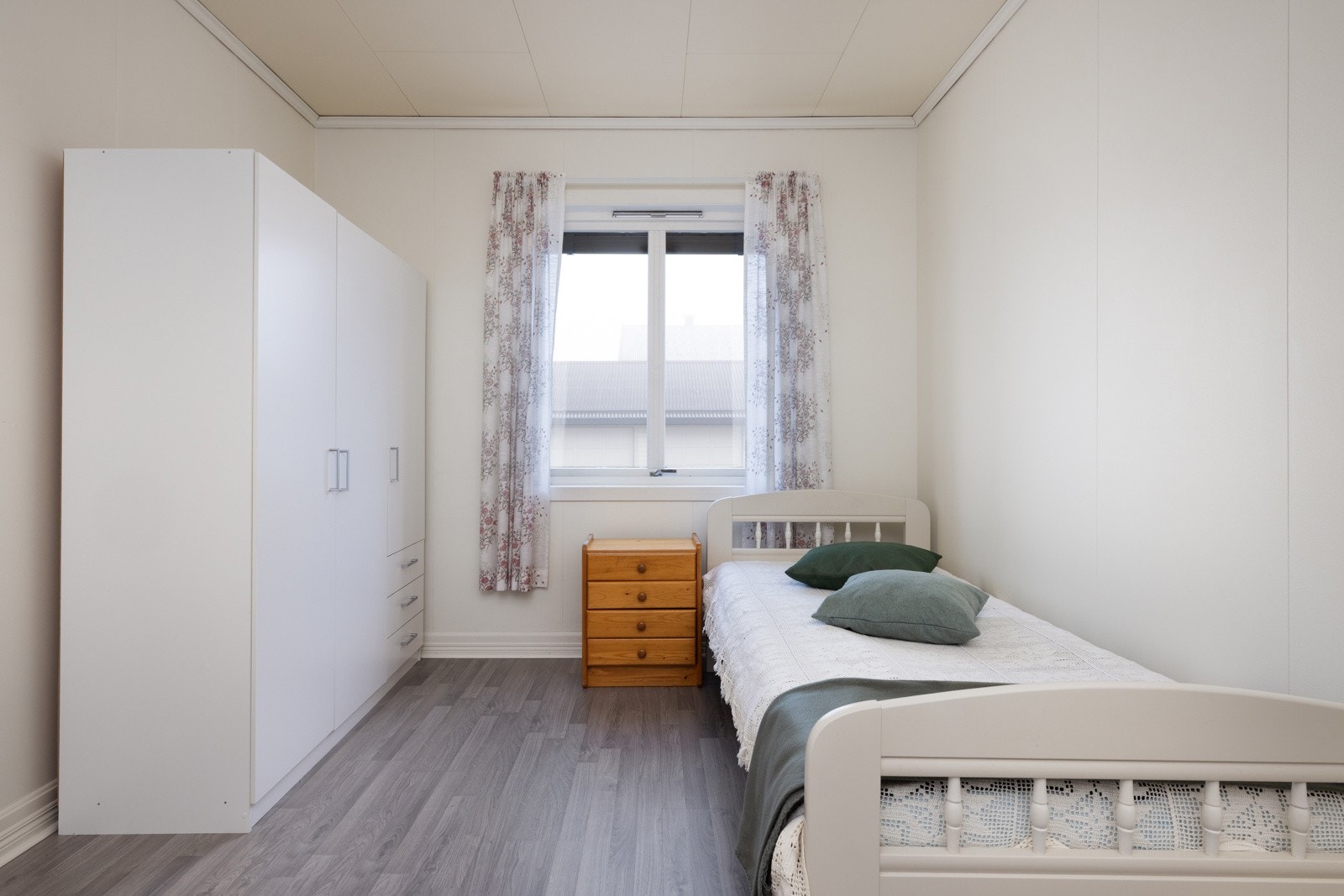 Lyst og pent soverom med laminatgulv og utvendige persienner. Galleribilde