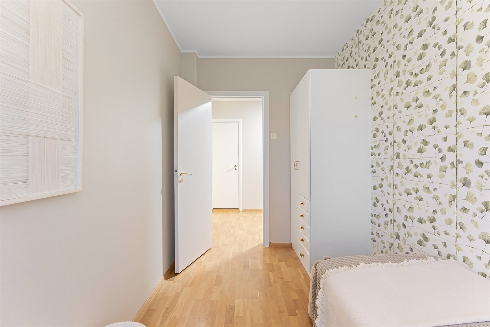 Rommet har parkett på gulv og en fondvegg med tapet. Galleribilde