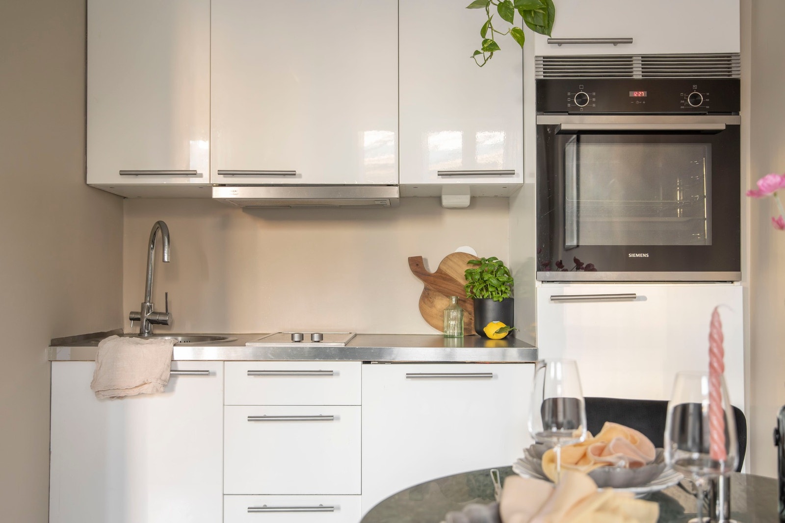 Moderne kjøkken med lyse fargetoner som står i stil til resten av leiligheten. Galleribilde