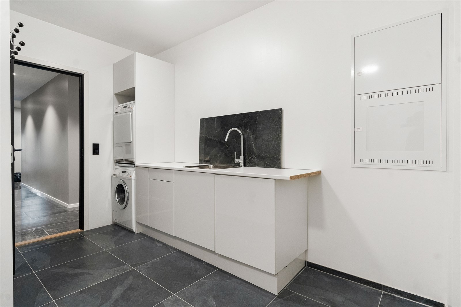 Romslig vaskerom med flislagt gulv med varme og god oppbevaringsplass. Galleribilde