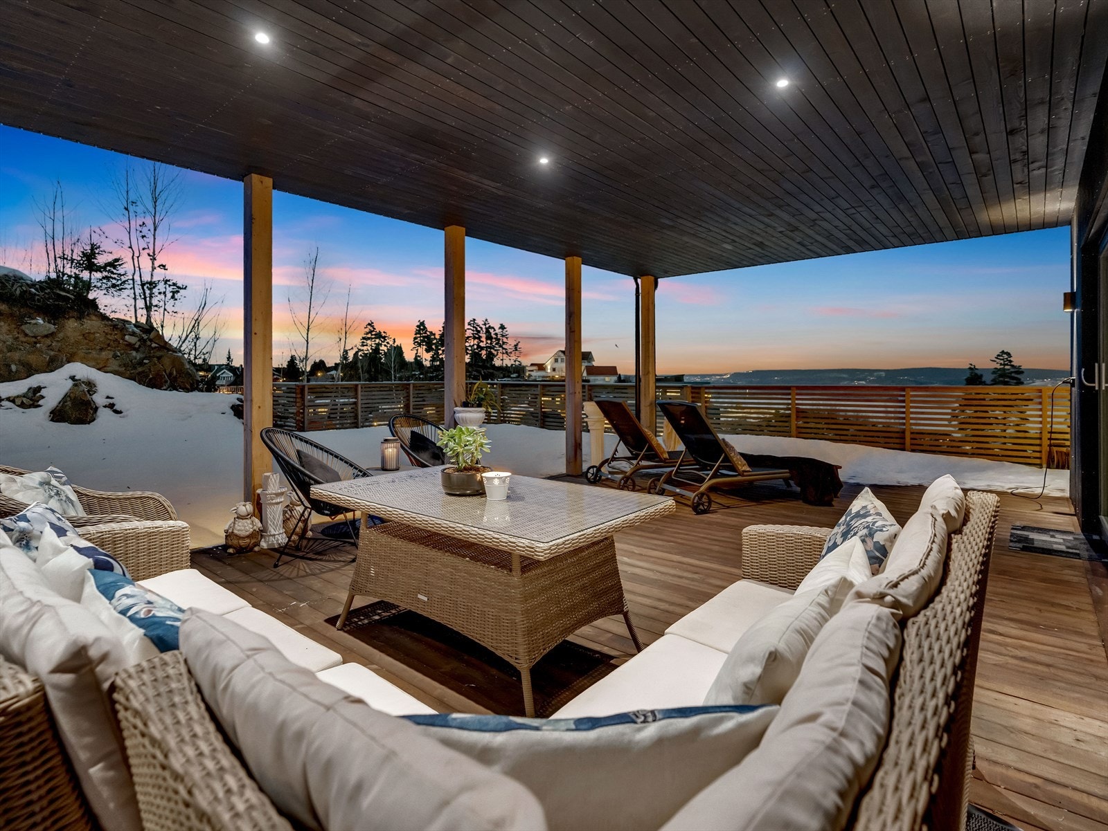 Terrassen strekker seg rundt boligen og oppleves som svært usjenert. Det er utebelysning i taket og rekkverk i metall med glassfelt foran stuevinduene og treverk på resterende del. Galleribilde