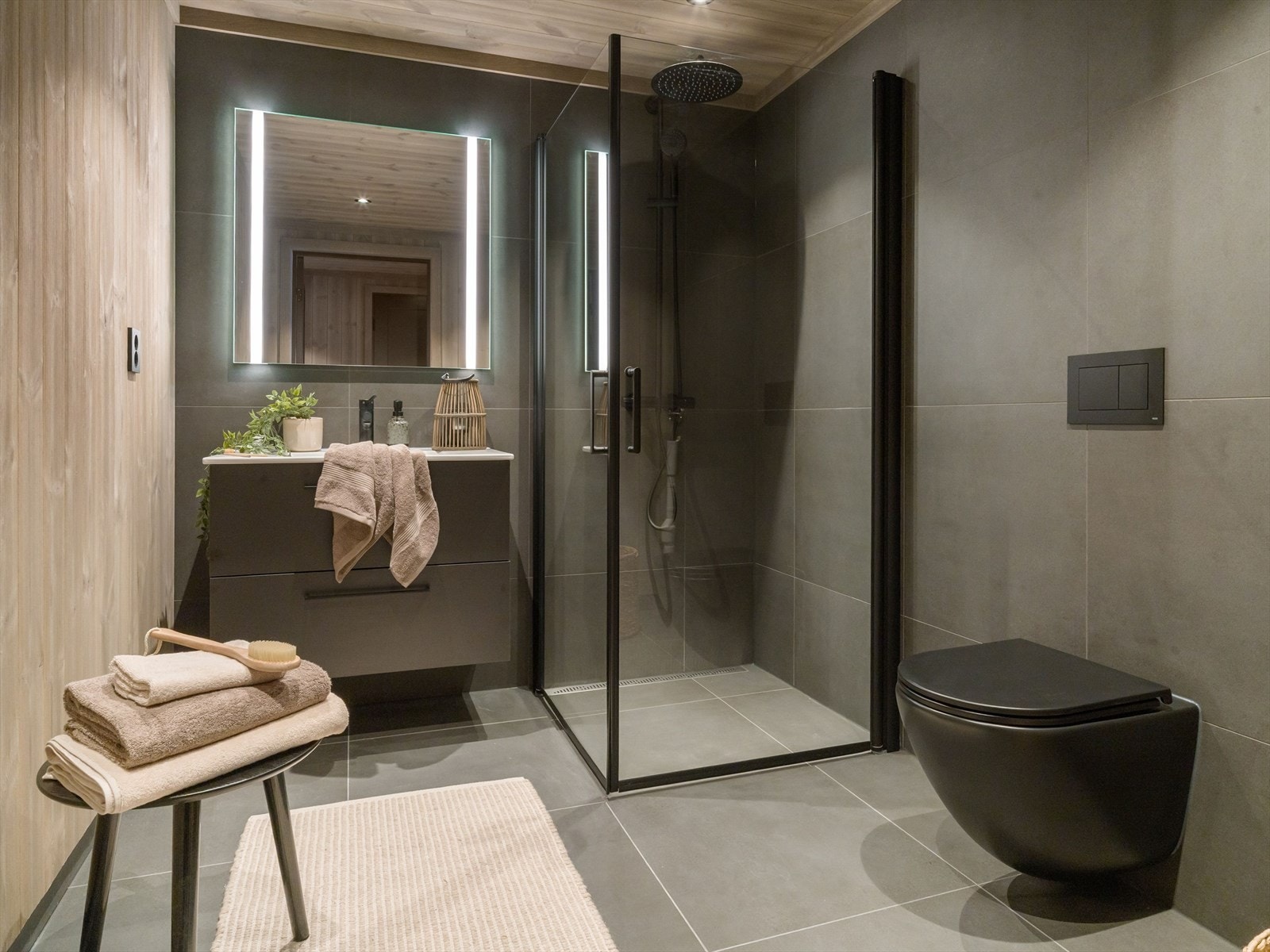 Her er det gulvvarme for ekstra komfort, samt moderne, sorte baderomsdetaljer. Galleribilde