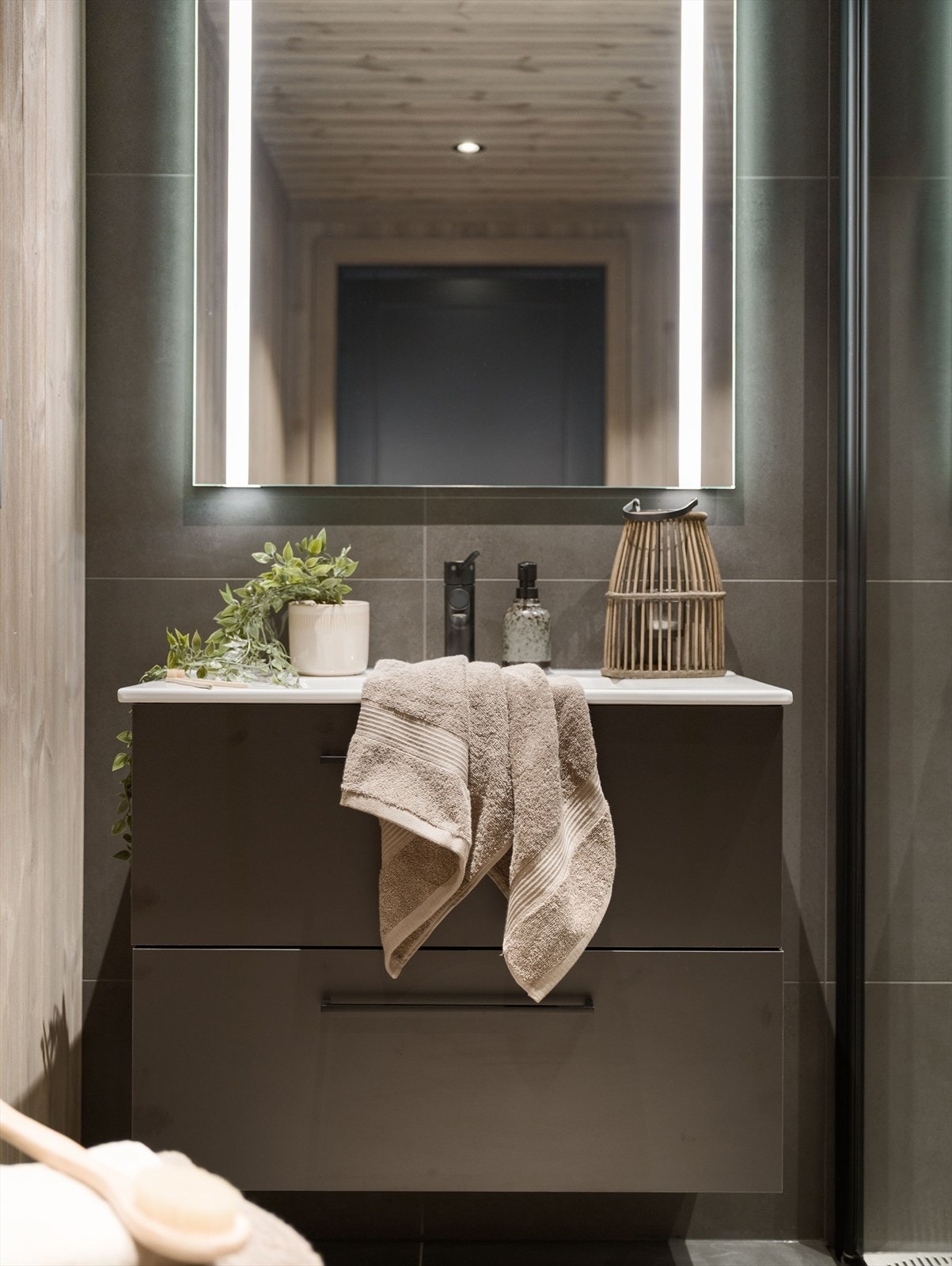 Detaljene er gjennomførte, med sort armatur og servant i et moderne formspråk. Galleribilde