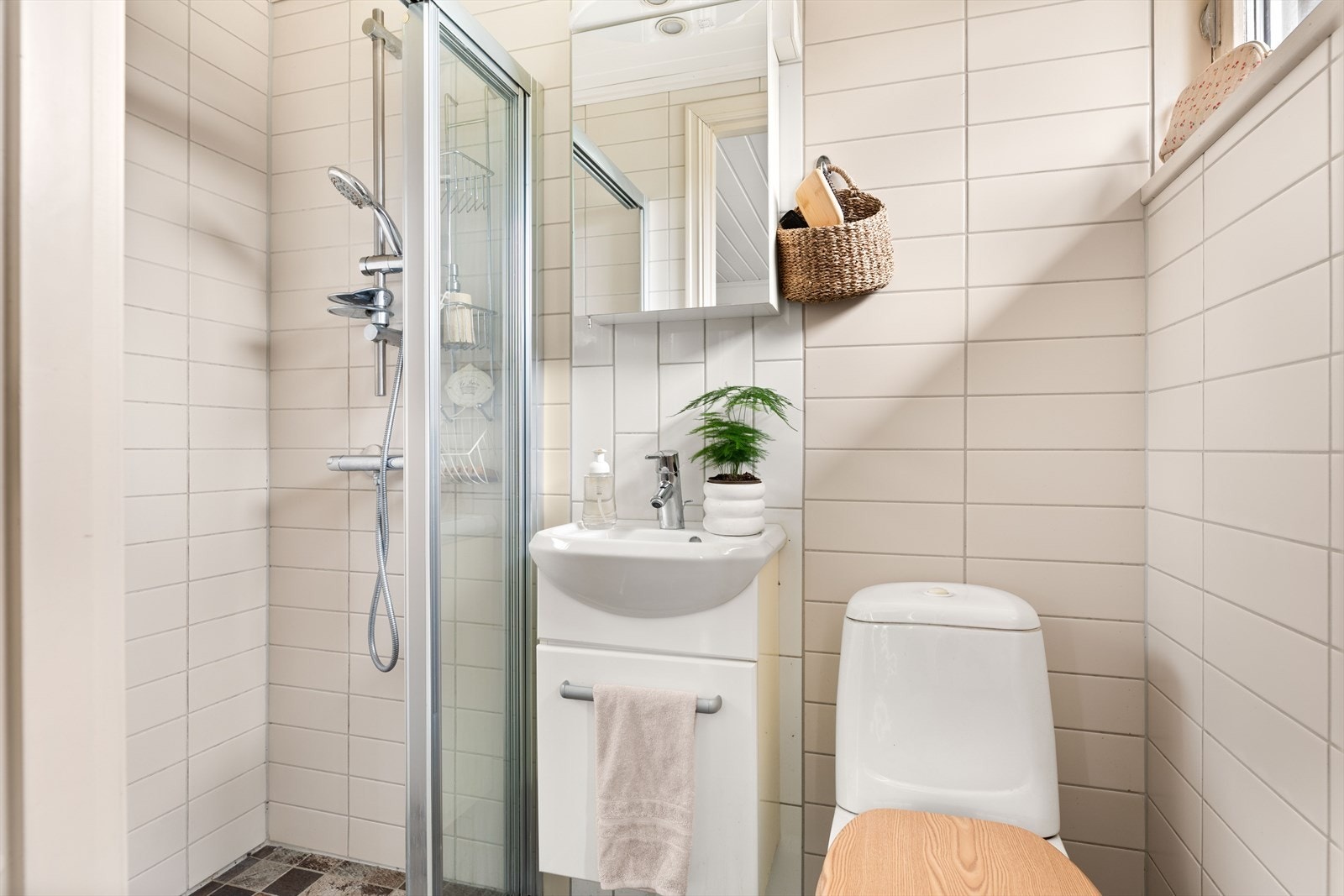 Badet i første etasje er flislagt, bestående av innredning med nedfelt servant, toalett og dusjvegger/hjørne. Varmekabler i gulv. Galleribilde