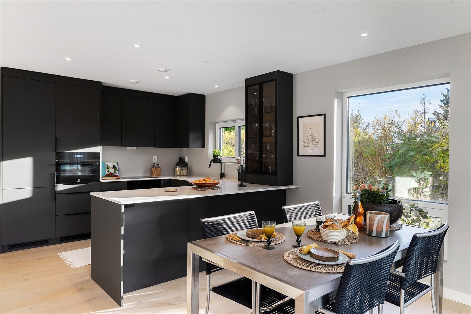 Den utvidede kjøkkenløsningen fungerer som både ekstra arbeidsflate og en naturlig sone for sitteplasser Galleribilde