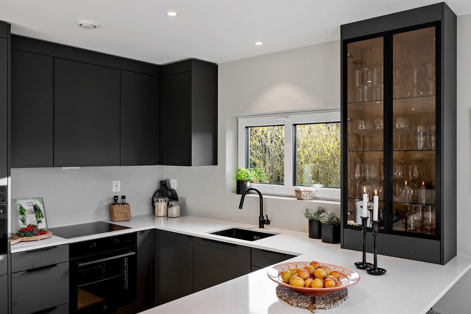 Moderne og stilrent kjøkken fra Artex med slette, mørke fronter og benkeplate i lys stein Galleribilde