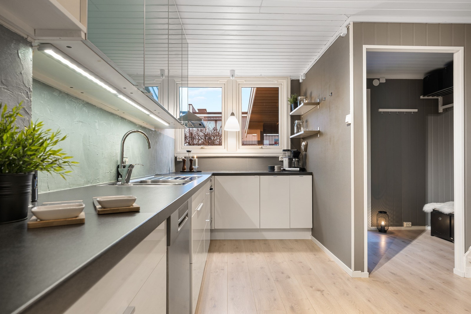 Kjøkkeninnredningen har slette fronter og inkluderer benkeskap, overskap og ett høyskap for praktisk oppbevaring Galleribilde