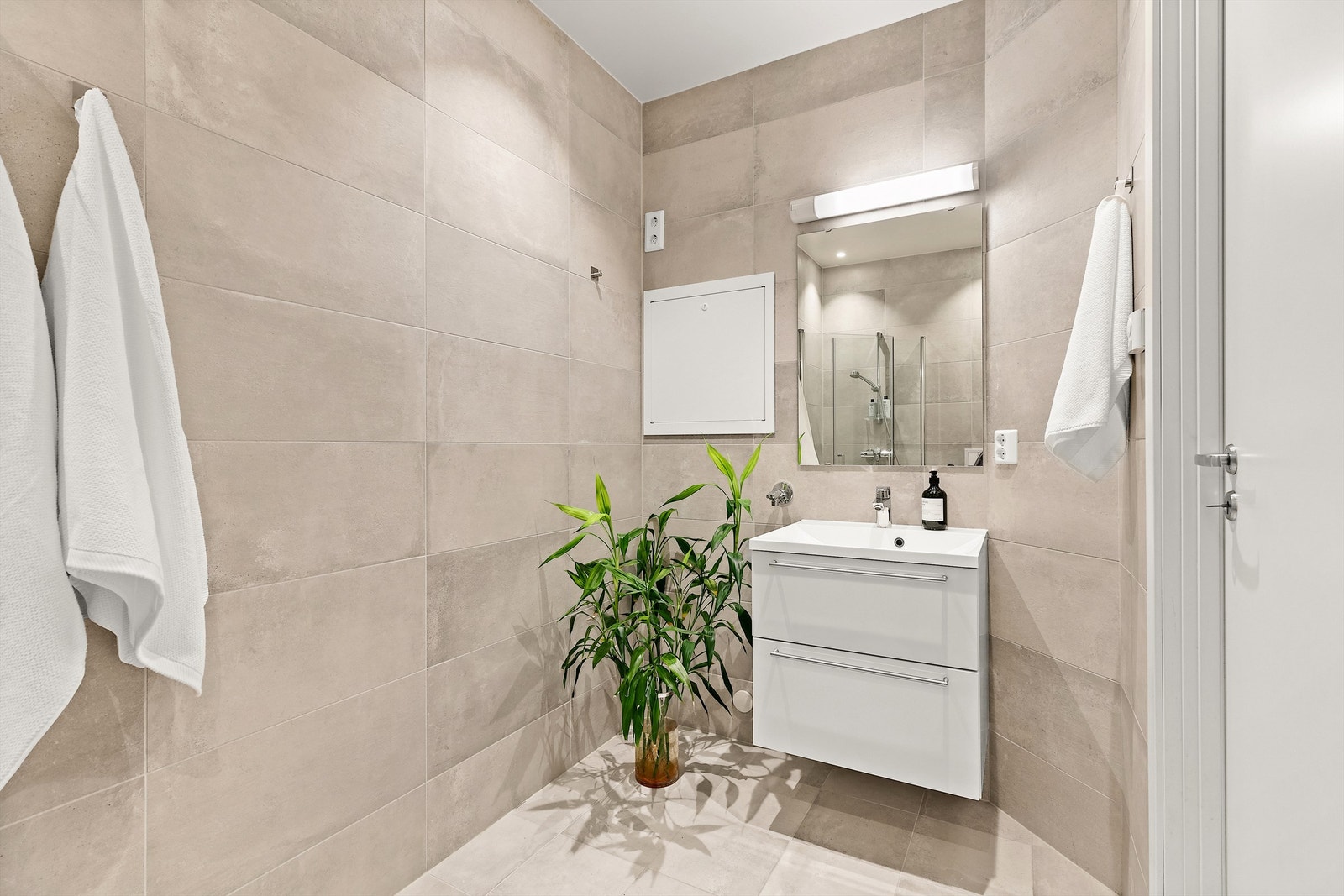 Dusjhjørne med innfellbare vegger, samt servantskap med oppbevaring. Det er også opplegg for vaskemaskin. Galleribilde