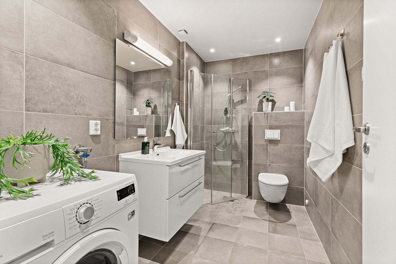 Bad i underetasje med moderne flisvalg, dusjhjørne og down-lights. Galleribilde