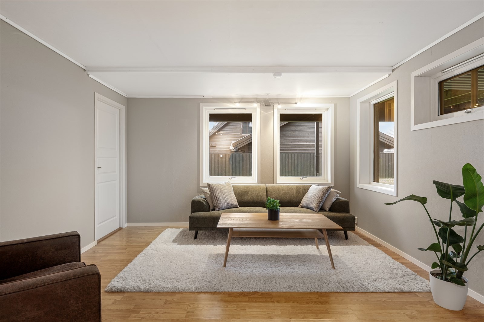 Stue i leilighet har store vindusflater som gir rikelig med lys. Galleribilde