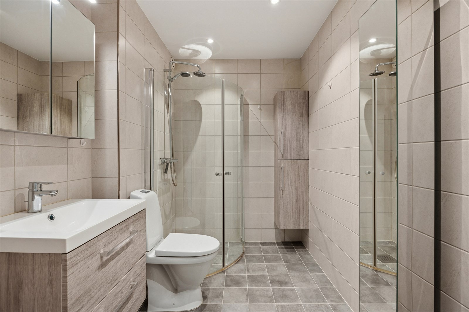 Baderommet er flislagt med varmekabler i gulv, frittstående toalett, god skapplass og dusj på vegg Galleribilde