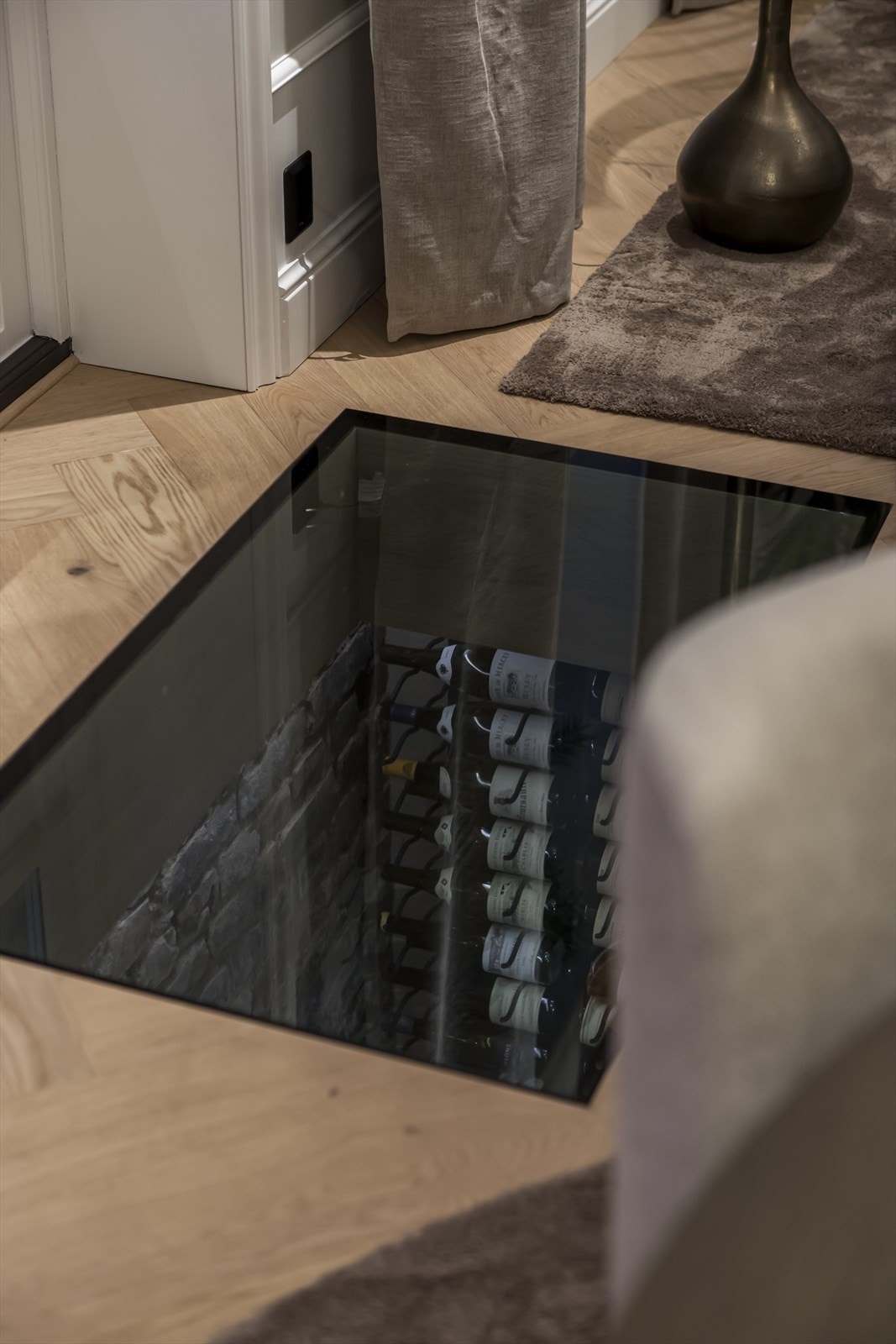 Ved terrassedøren har rommet et stilig glassgulv til vinkjelleren - et blikkfang som gir leiligheten det lille ekstra. Galleribilde