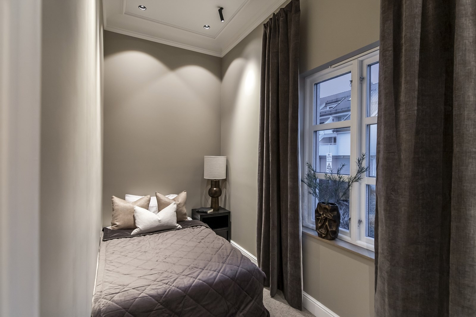 Begge rommene har downligts, bred listedekor og innebygde garderobeskap holdt i den samme gråtonen som veggene. Galleribilde