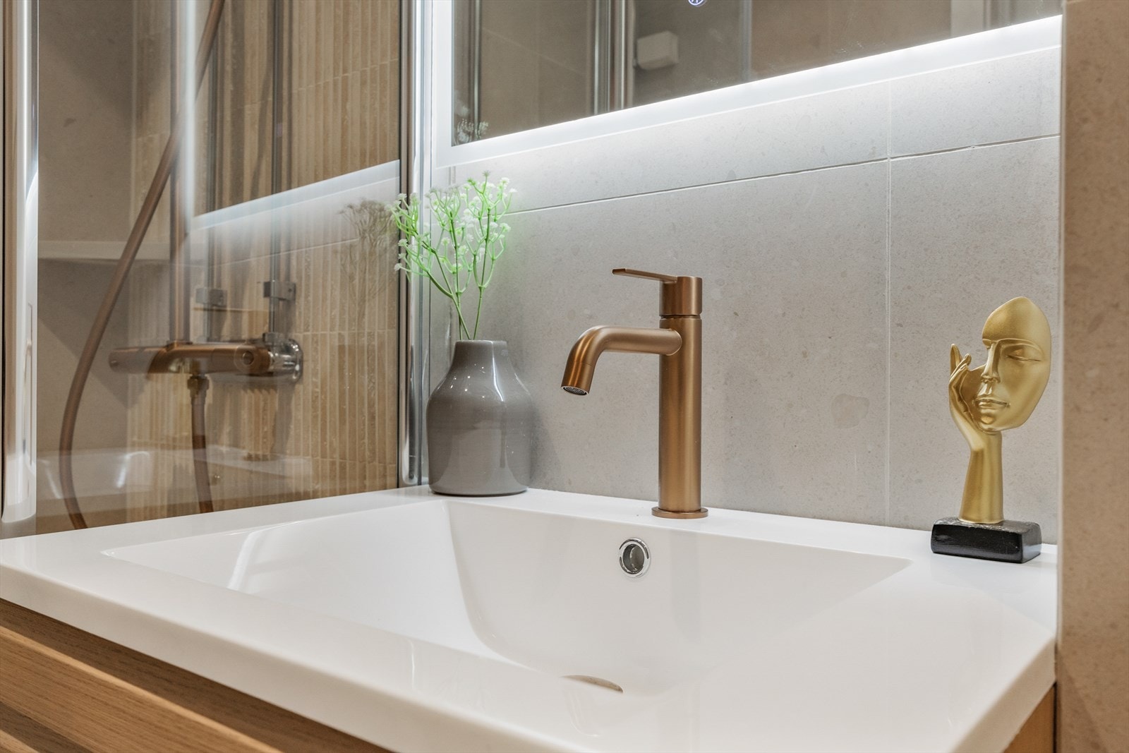 Moderne servantseksjon med skuffer og et speil med integrert belysning. Galleribilde