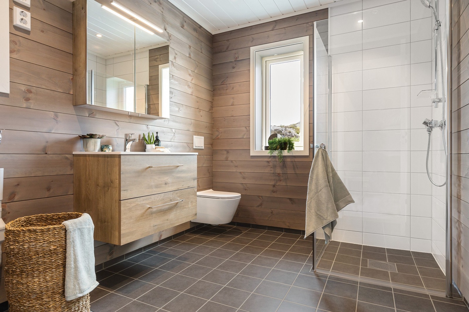 På badet er det vegghengt toalett, servant med innredning og dusjhjørne med glassdører. Galleribilde