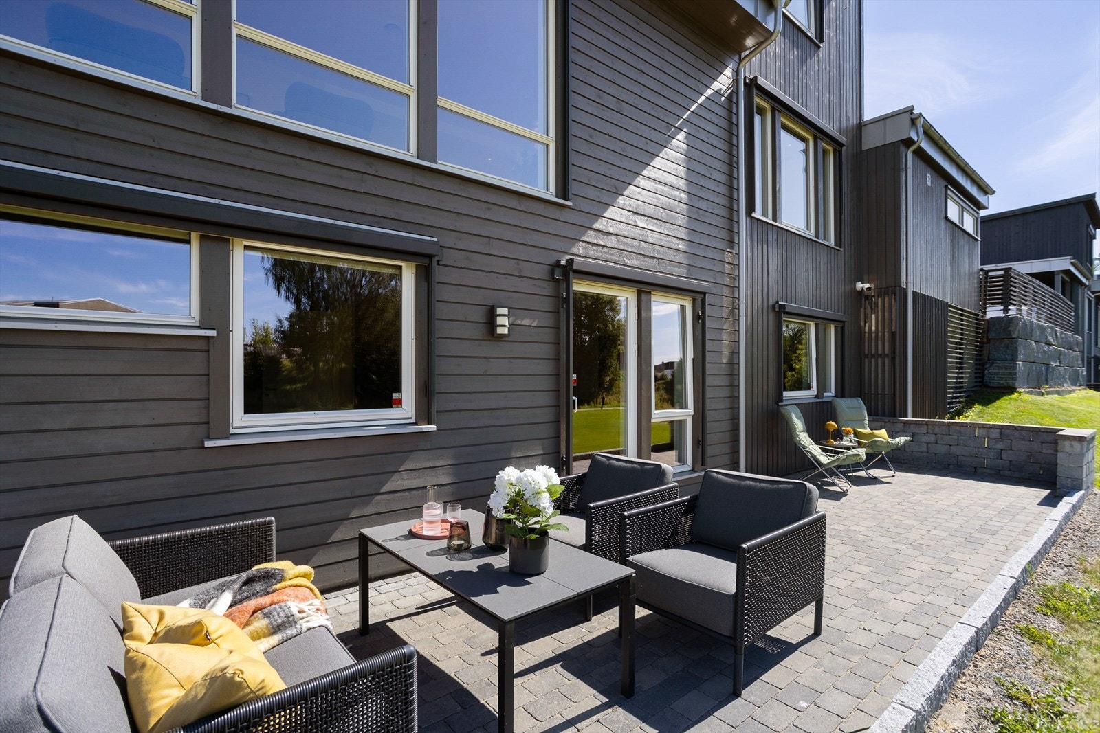 Markterrassen er steinsatt og har direkte adkomst til hageområdet - praktisk og lettstelt for barnefamilien Galleribilde