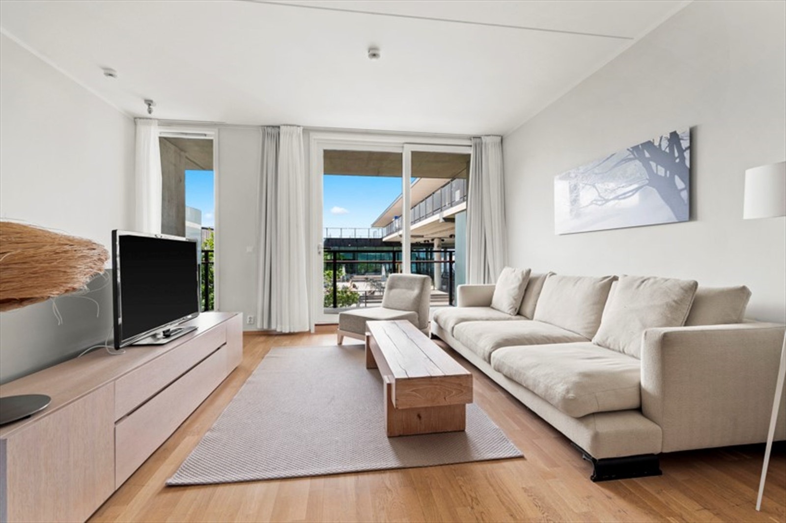 Stue med parkett på gulv og utgang til solrik og flott veranda Galleribilde