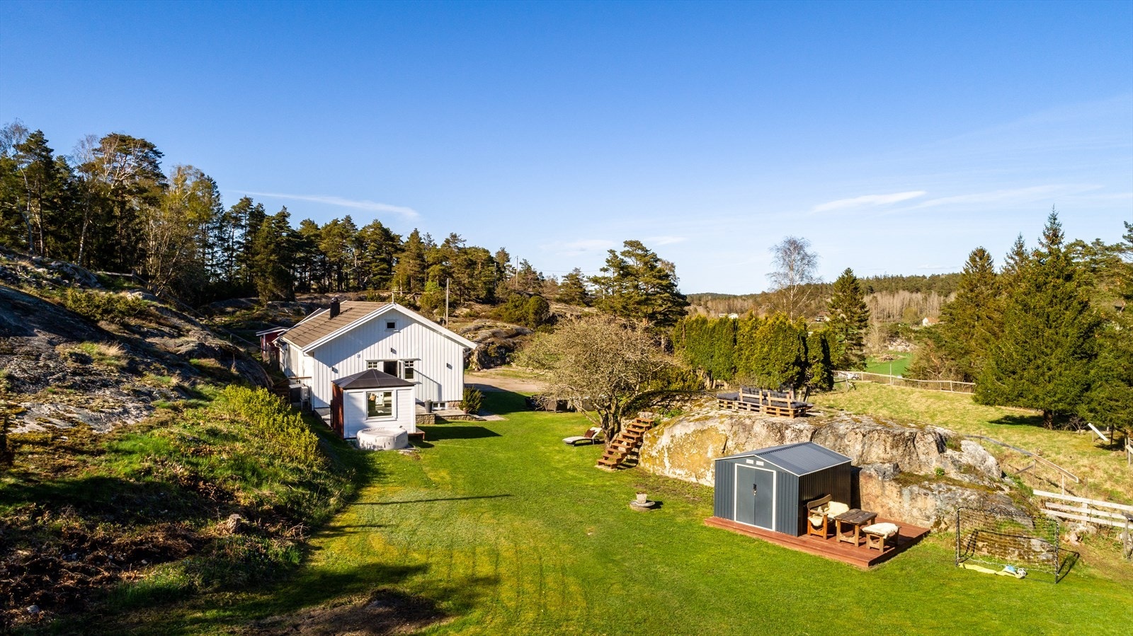 Her, på en vakker og fredelig høyde omgitt av glattskurte svaberg, furuskog og fuglesang, ligger en sjarmerende eiendom hvor småbruksdrømmen kan bli virkelighet. Galleribilde